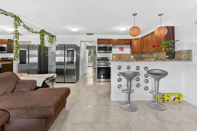 a kitchen with granite countertop a sink a stove and a wooden cabinets