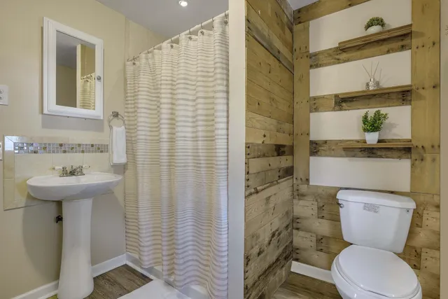 a bathroom with a sink a toilet and shower