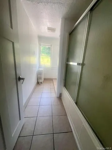 an empty room with wooden floor and windows with curtains
