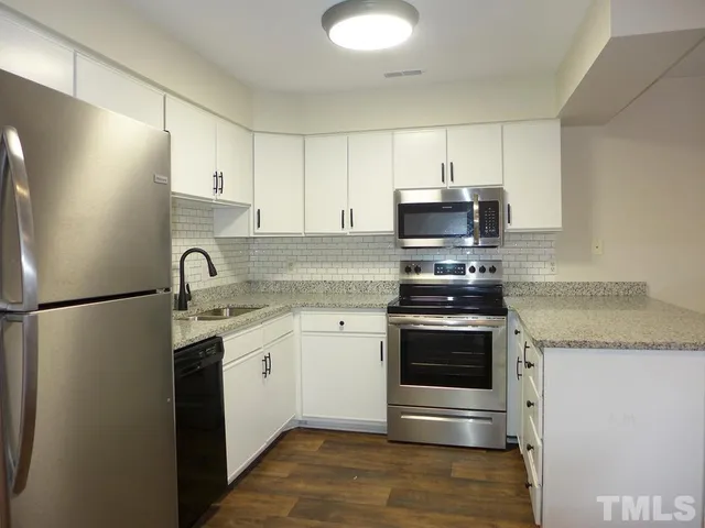 a kitchen with stainless steel appliances granite countertop a refrigerator stove and sink