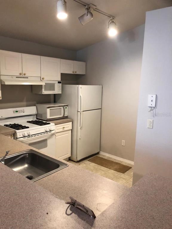 3397 South Kirkman Road, Unit 1435 Orlando, FL 32811 - Photo 2 of 11 a kitchen with appliances and cabinets