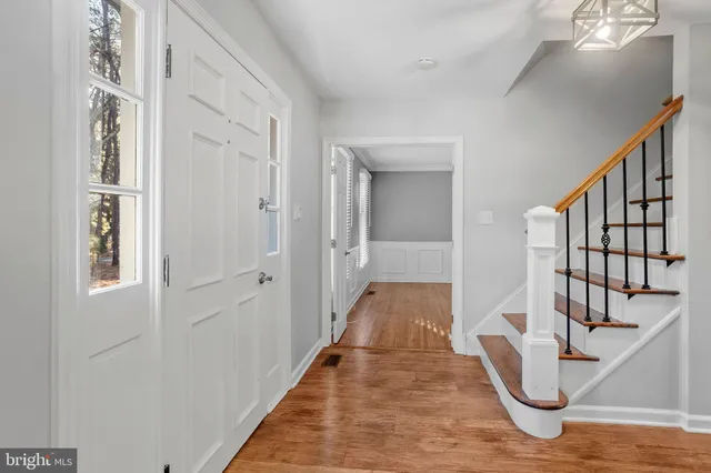 a view of a hallway with wooden floor and staircase