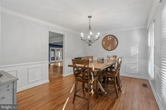 a view of a dining room with furniture a chandelier and wooden floor