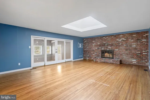 a view of empty room with wooden floor and fireplace