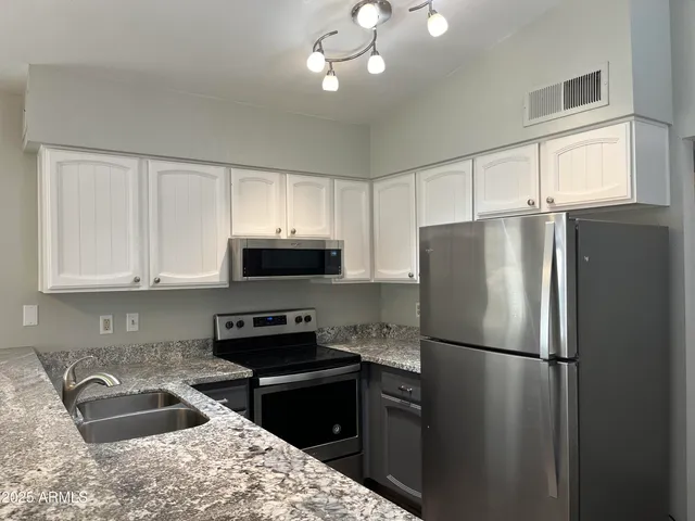 a kitchen with a refrigerator stove and sink