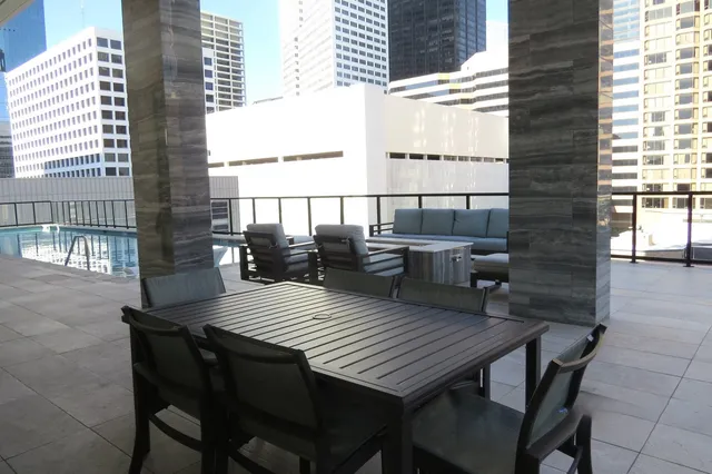 a view of a wooden table and chairs on the roof deck