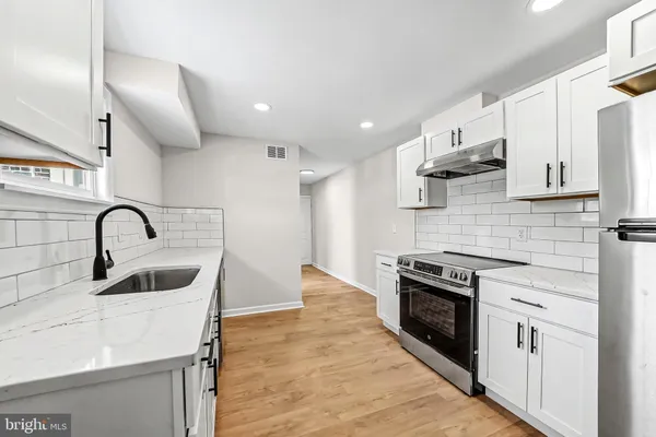 a kitchen with stainless steel appliances a stove sink and cabinets