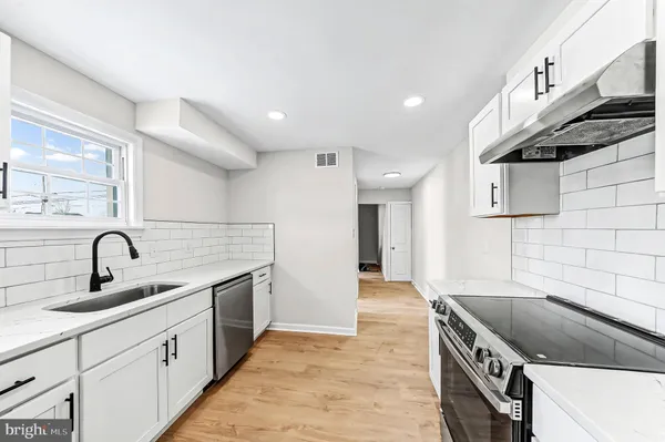 a kitchen with stainless steel appliances granite countertop a sink and a stove top oven