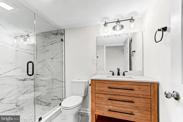 a bathroom with a sink vanity mirror and toilet