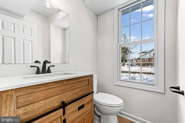 a bathroom with a sink a toilet and a window