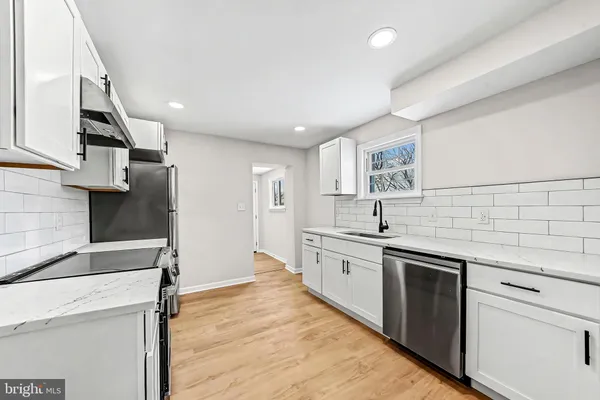 a kitchen with stainless steel appliances granite countertop a sink and dishwasher a stove top oven with wooden floor