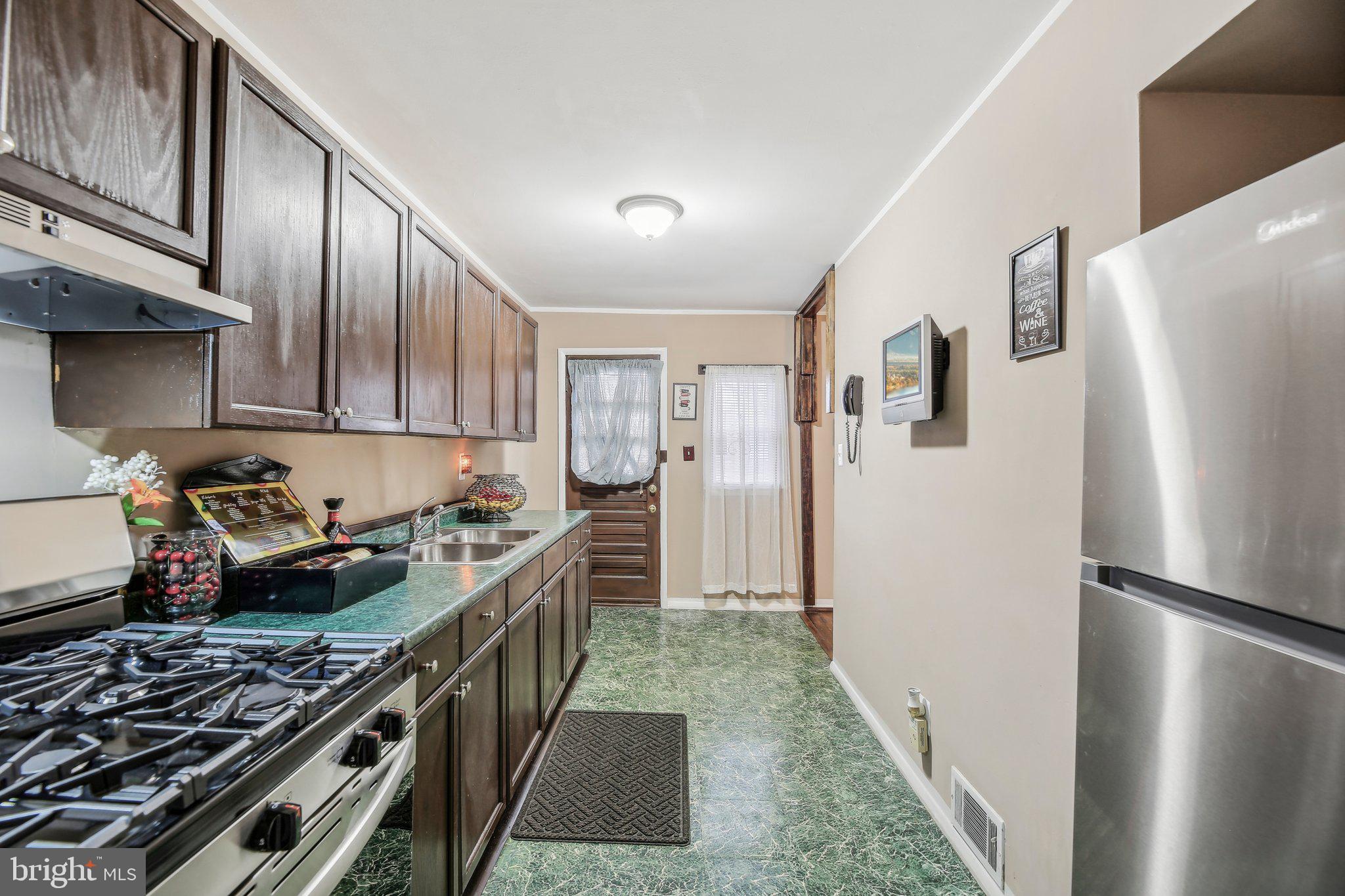 904 North Rosedale Street Baltimore, MD 21216 - Photo 14 of 38 a kitchen with stainless steel appliances granite countertop a stove top oven a refrigerator a sink and dishwasher