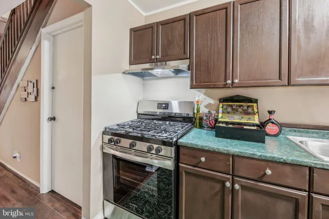 a kitchen with granite countertop wooden cabinets and a stove top oven