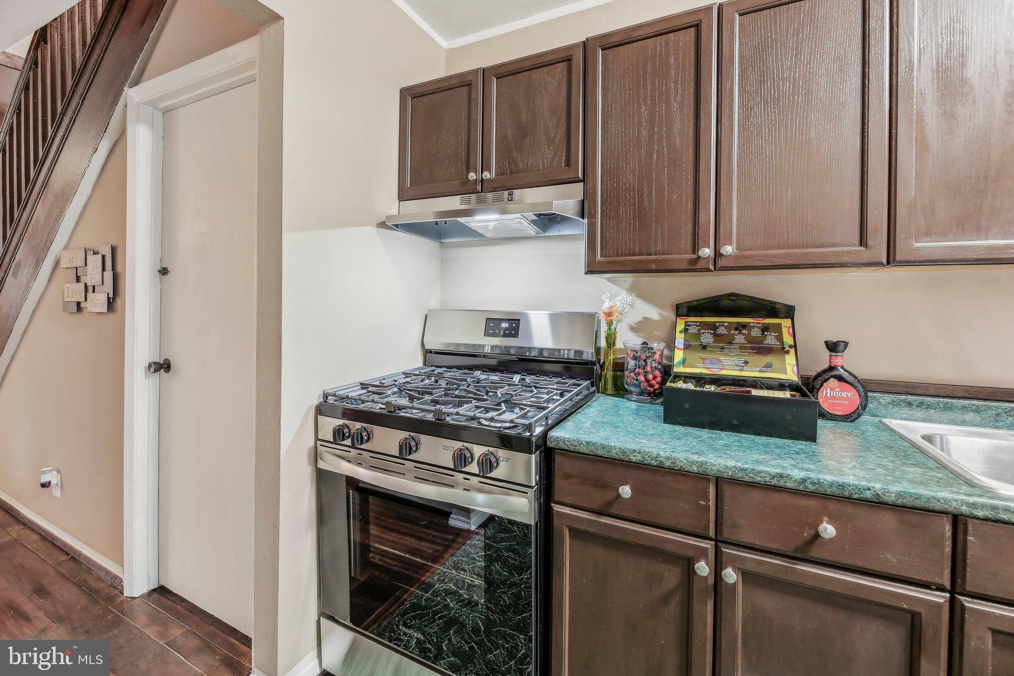 904 North Rosedale Street Baltimore, MD 21216 - Photo 15 of 38 a kitchen with granite countertop wooden cabinets and a stove top oven