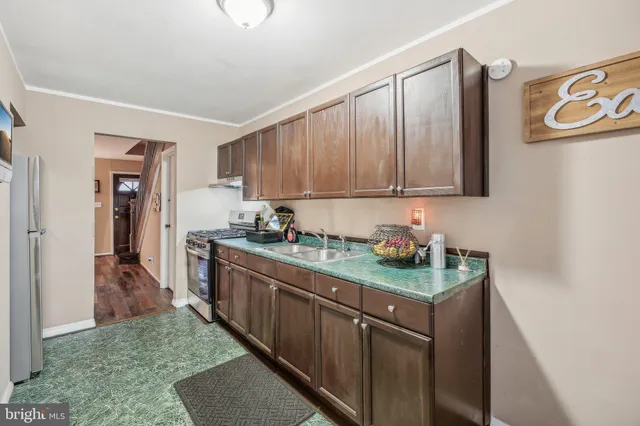 a kitchen with stainless steel appliances granite countertop a refrigerator and a stove top oven