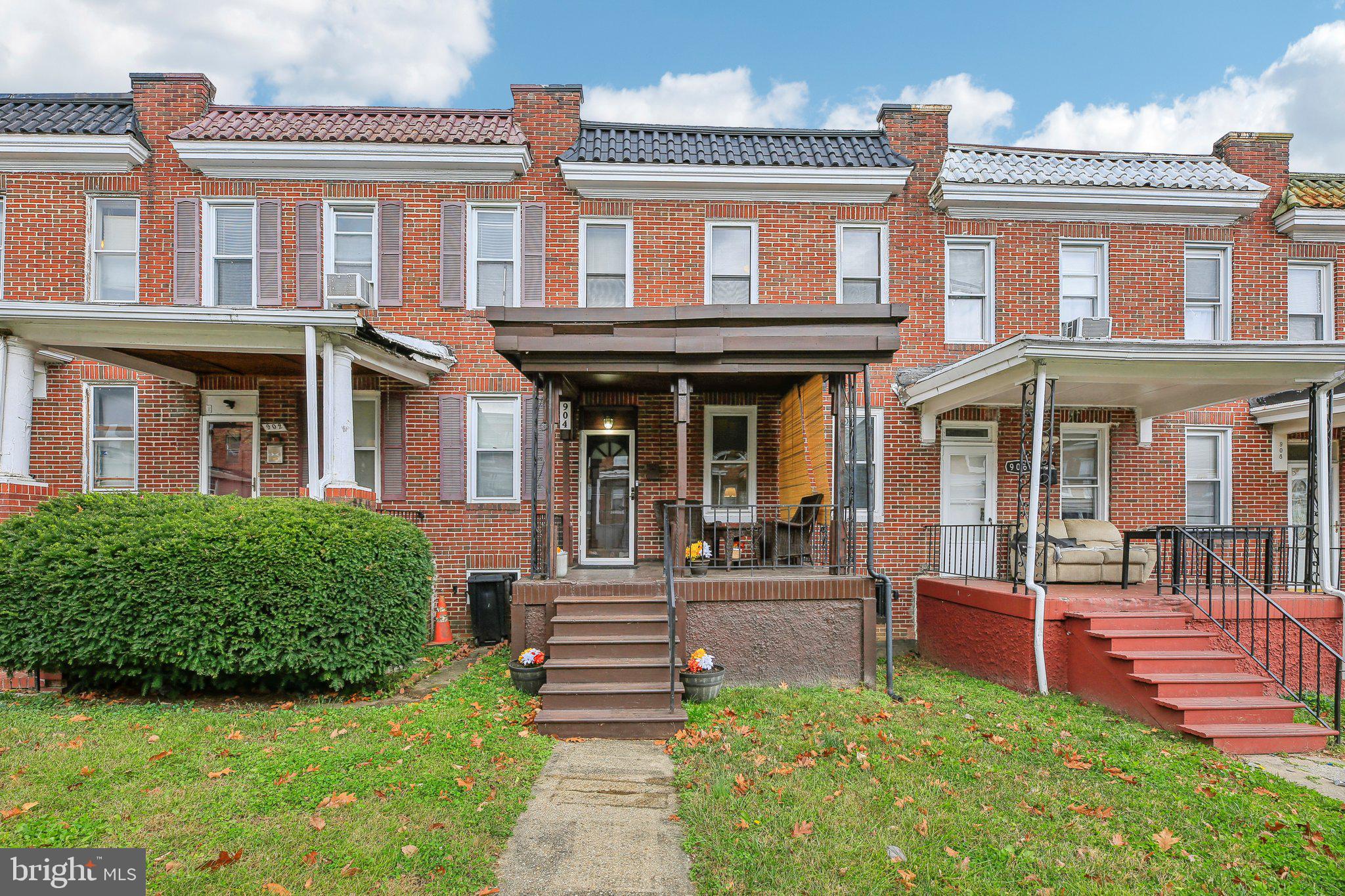 904 North Rosedale Street Baltimore, MD 21216 - Photo 2 of 38 a front view of a brick house with a yard table and chairs