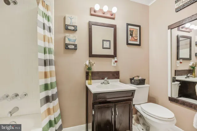 a bathroom with a sink a toilet and shower curtain