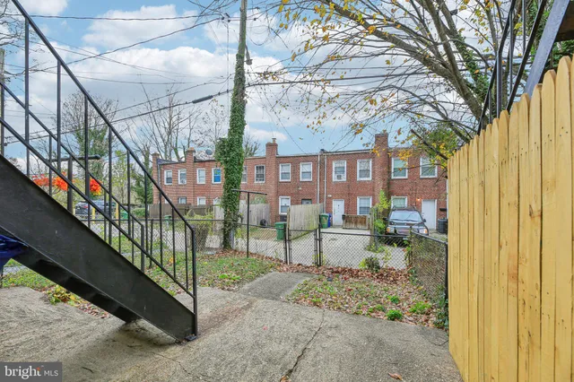 a view of a house with a small yard and wooden fence