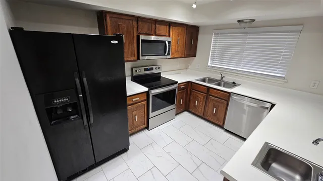 a kitchen with stainless steel appliances granite countertop a refrigerator stove and sink