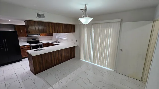 a kitchen with stainless steel appliances granite countertop a stove a refrigerator and a cabinets