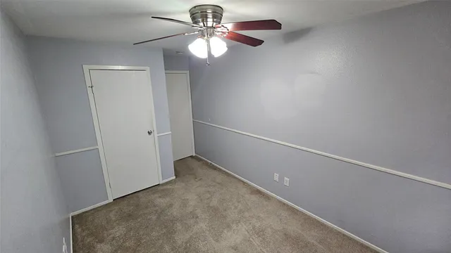 an empty room with a chandelier fan