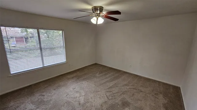 a view of a livingroom with a ceiling fan and window