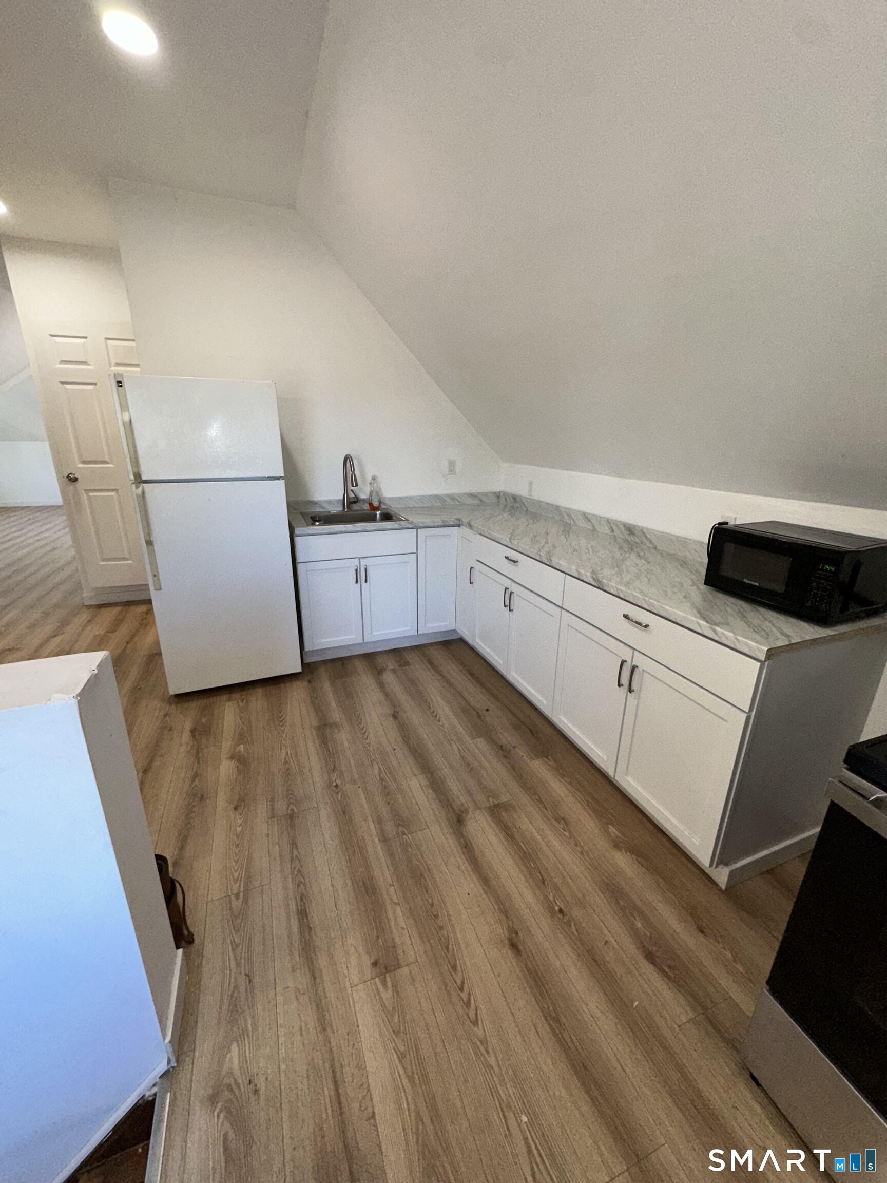 27 East 9th Street Derby, CT 06418 - Photo 7 of 22 a kitchen with cabinets and wooden floor