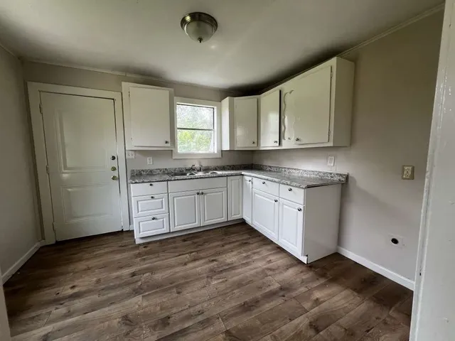 a kitchen with stainless steel appliances granite countertop a sink a stove and cabinets