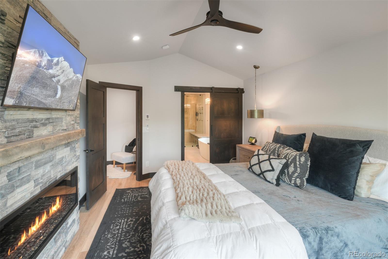 306 Golden Eagle Road Silverthorne, CO 80498 - Photo 20 of 43 a spacious bedroom with a bed and a chandelier