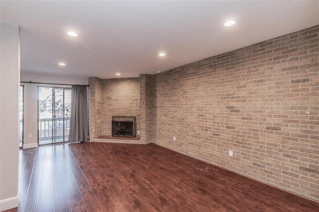4930 Thunder Road Dallas, TX 75244 - Photo 17 of 23 Wood-finish flooring, recessed lighting, brick accent wall, built-in fireplace, and sliding glass doors to outdoor space