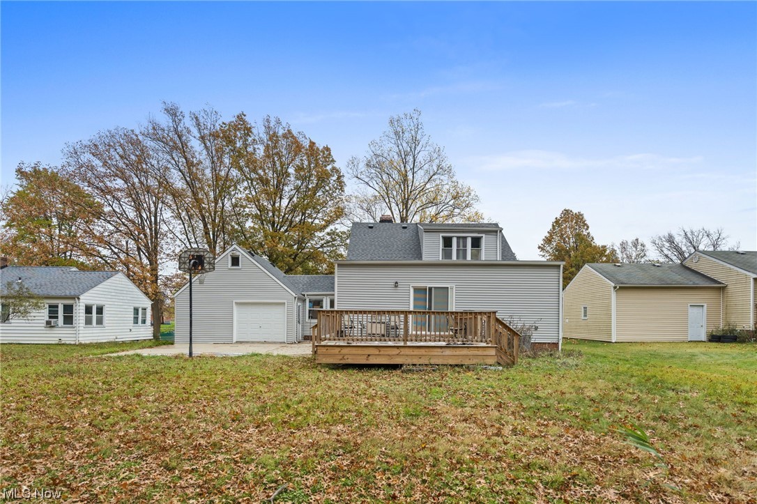 6454 Crossview Road Independence, OH 44131 - Photo 23 of 27 Rear view of property featuring a garage, a wooden deck, and a lawn