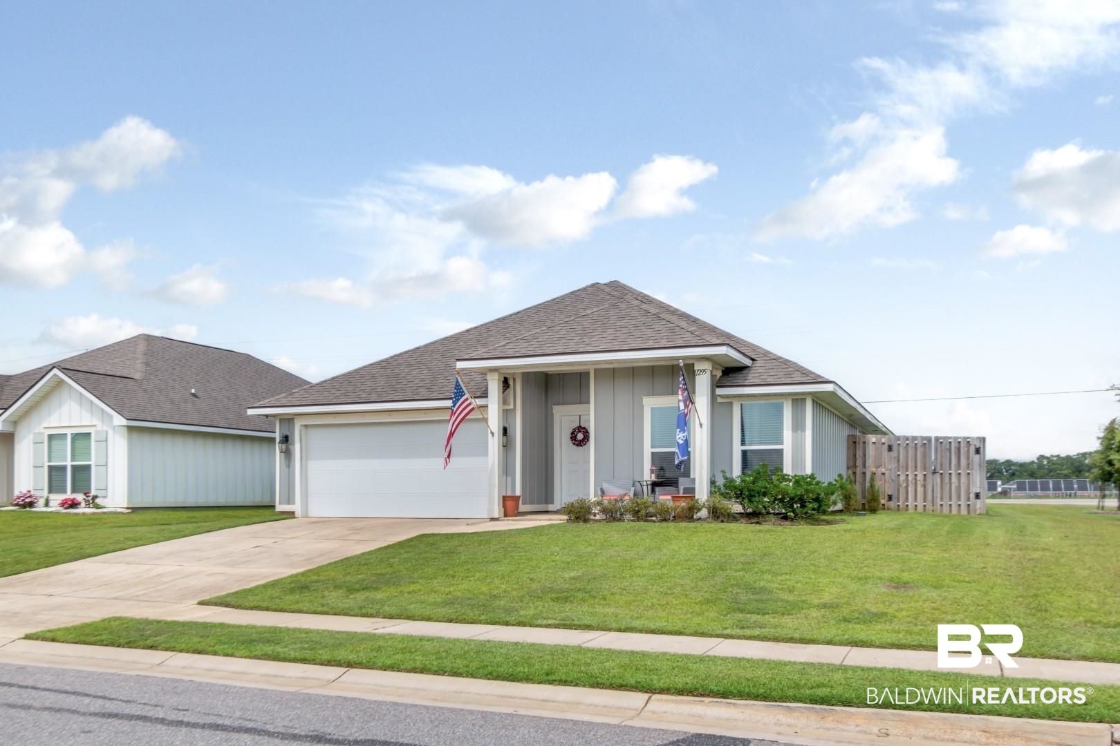 1295 Hayward Loop Foley, AL 36535 - Photo 27 of 29 Single-story residence featuring a covered front porch, an attached two-car garage, and a light gray exterior