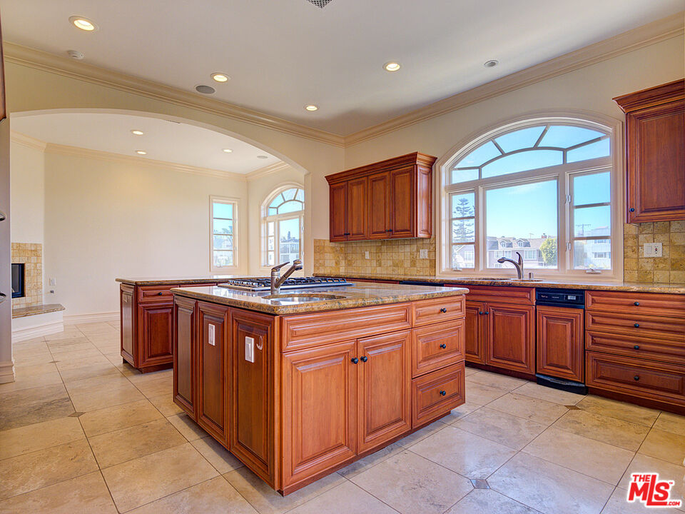 5003 Roma Court Venice, CA 90292 - Photo 12 of 34 a large kitchen with stainless steel appliances a large counter top a stove a sink and a refrigerator