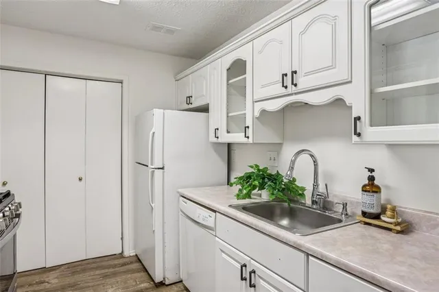 a kitchen with stainless steel appliances white refrigerator a sink and cabinets