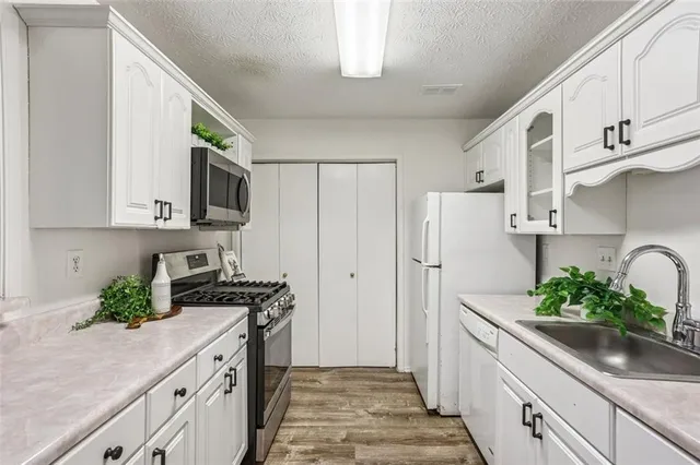 a kitchen with stainless steel appliances white cabinets and a stove