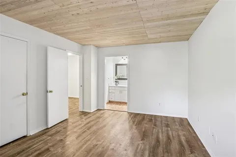 a view of a big room with wooden floor and windows