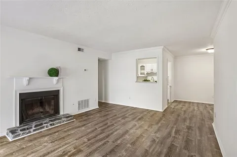 a view of empty room with wooden floor and fireplace