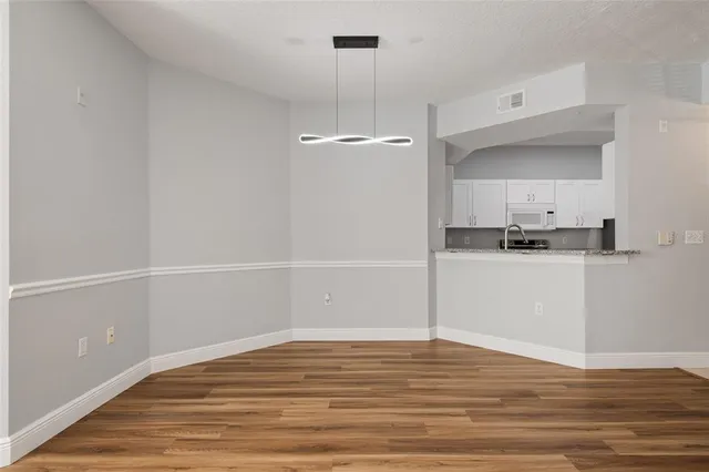 a view of a room with wooden floor and white walls