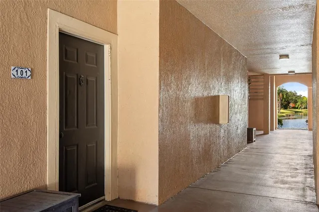 a view of a hallway with wooden floor and a bathroom