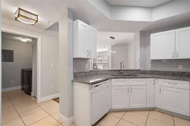 a kitchen with granite countertop white cabinets and appliances