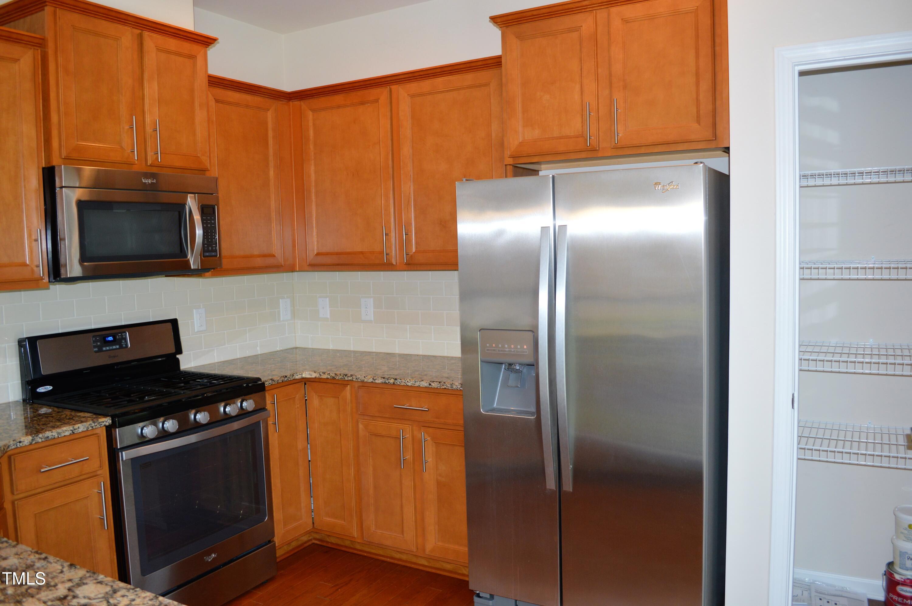 127 Brier Crossings Loop Durham, NC 27703 - Photo 5 of 14 a kitchen with granite countertop a refrigerator stove and microwave
