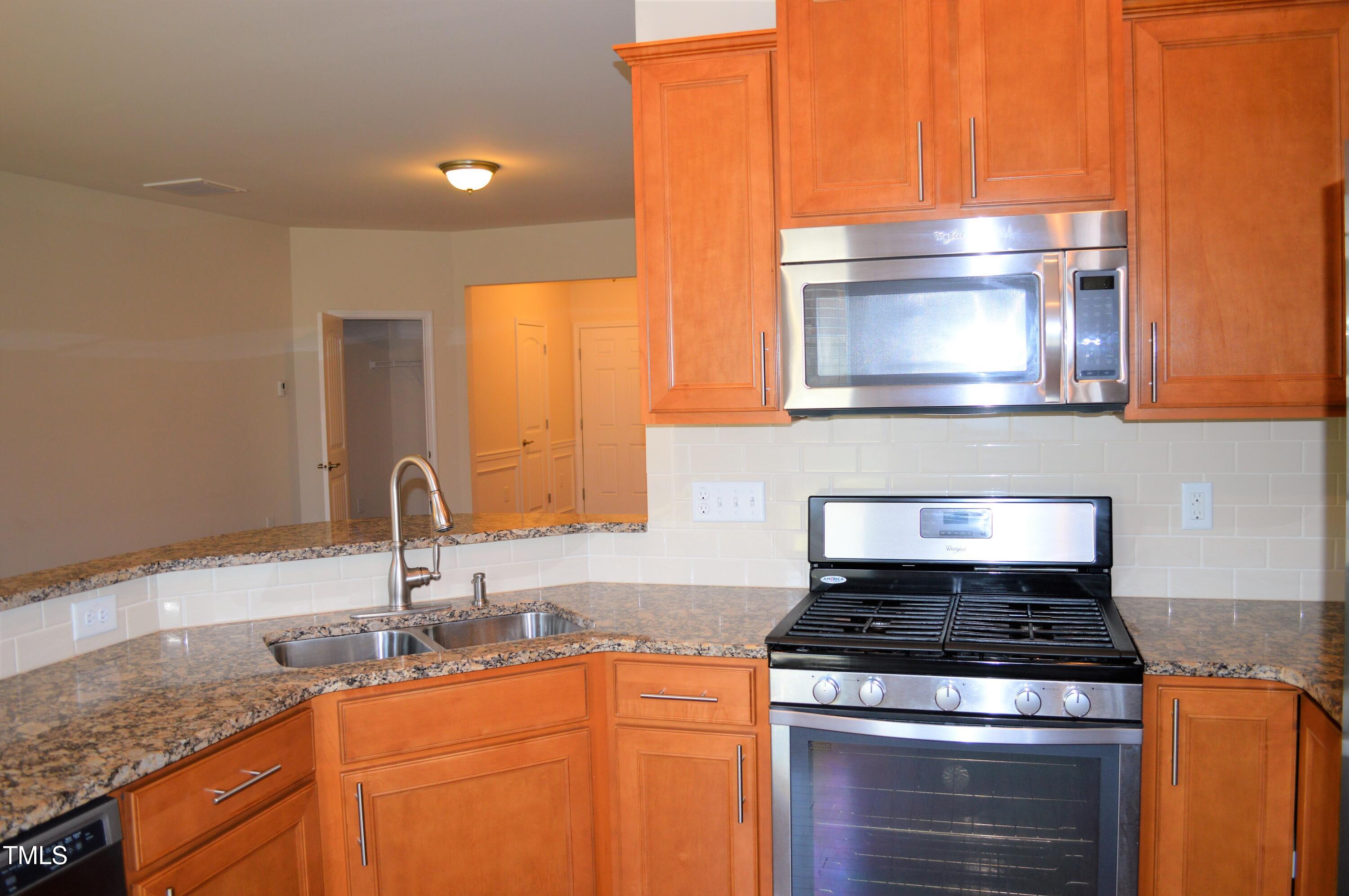 127 Brier Crossings Loop Durham, NC 27703 - Photo 6 of 14 a kitchen with granite countertop a sink stove and microwave