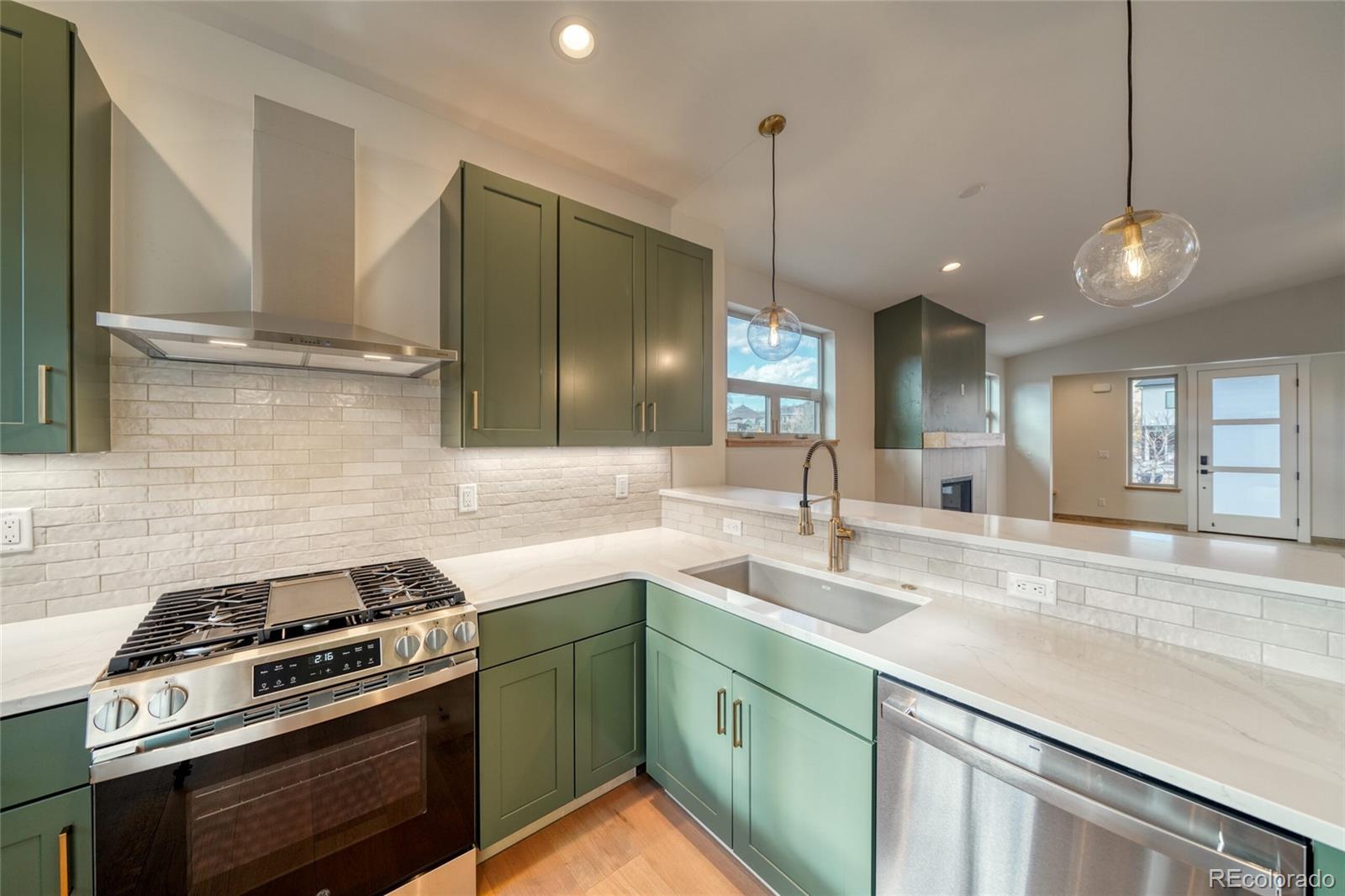 211 Southside Loop Salida, CO 81201 - Photo 19 of 39 a kitchen with stainless steel appliances granite countertop a sink a stove and a wooden floor