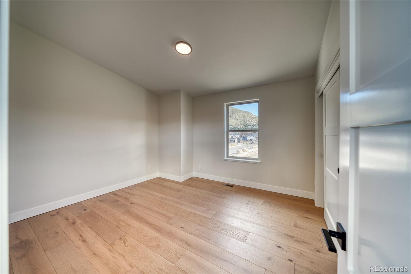 211 Southside Loop Salida, CO 81201 - Photo 29 of 39 an empty room with wooden floor and windows