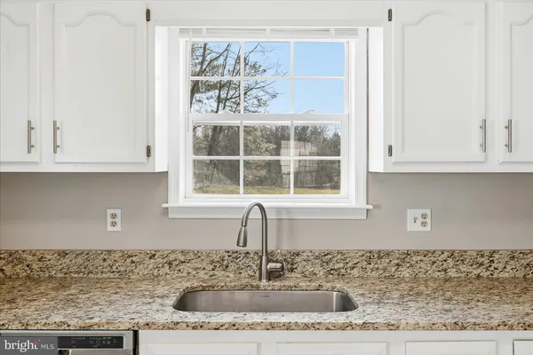 a large kitchen with stainless steel appliances granite countertop a refrigerator and a stove top oven
