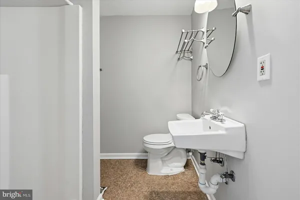 a bathroom with a sink a toilet and a mirror
