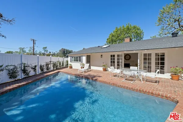 a view of a house with backyard and sitting area