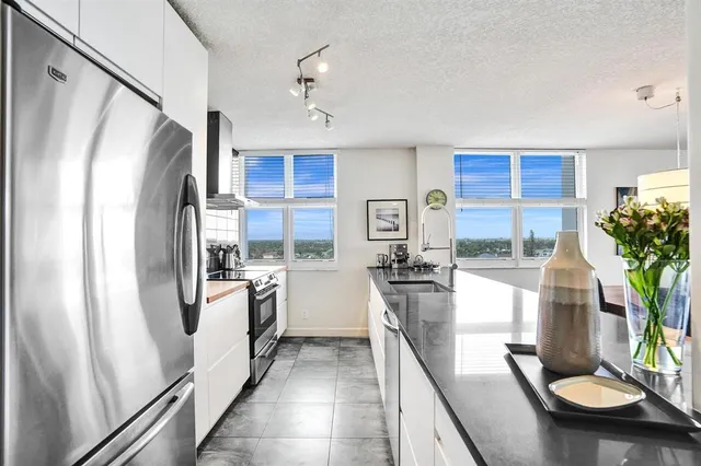 a living room with furniture kitchen view and a large window