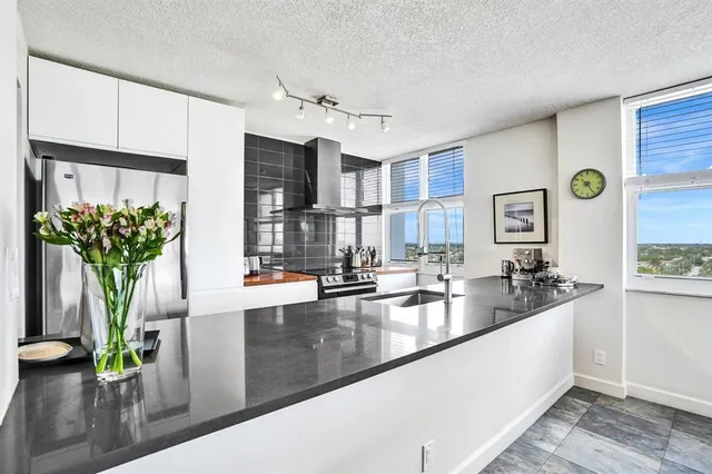 a kitchen with stainless steel appliances granite countertop a refrigerator and a sink