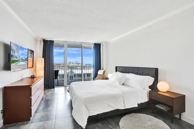 a view of a balcony with wooden chairs and floor to ceiling window